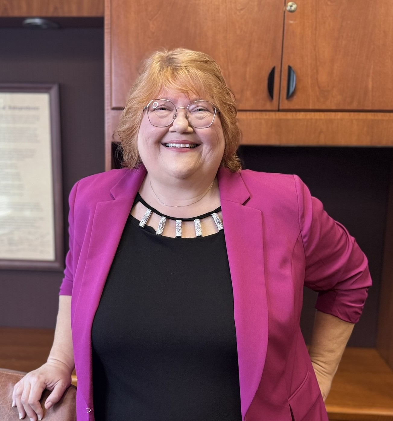  Adrienne Kwiatek-Holub wearing glasses a fuchsia blazer and a black shirt